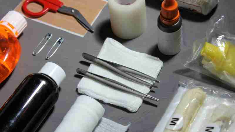 High-angle view of various essential first aid items, including bandages, gauze, scissors, and disinfectants on a table., tags: en - pexel